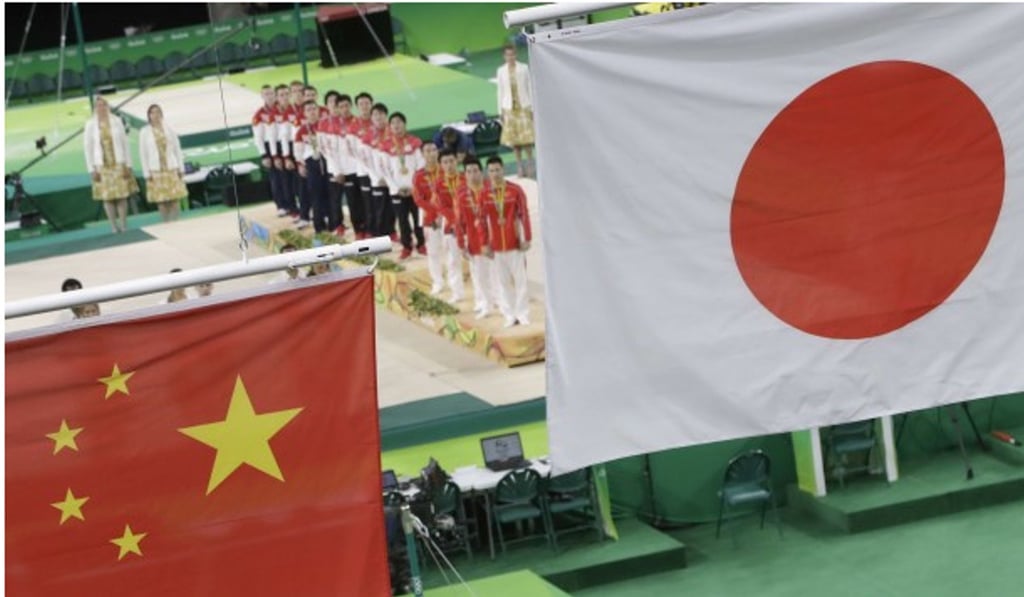 An incorrect version of the Chinese national flag is hoisted below the Japanese banner after Japan took the gymnastics team gold. Photo: AP