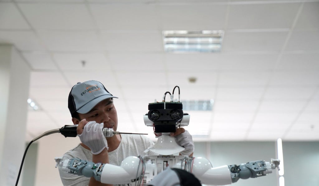 A worker puts finishing touches to a robot at an assembly plant in Suzhou, Jiangsu province, China. Photo: Reuters