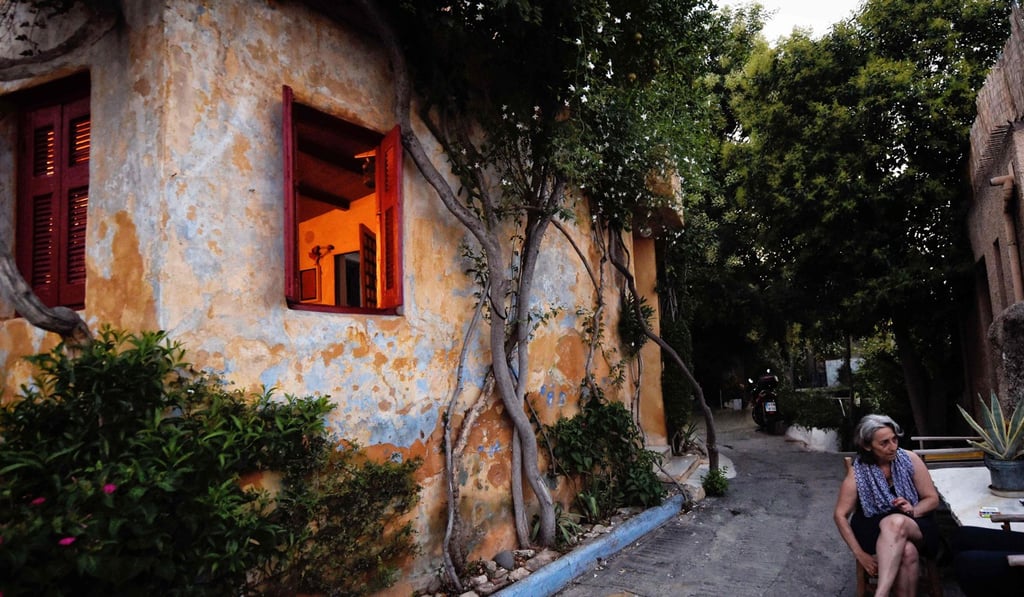 Anafiotika resident Alexandra Katoueani sits on a street in the tiny neighbourhood. Photo: AFP