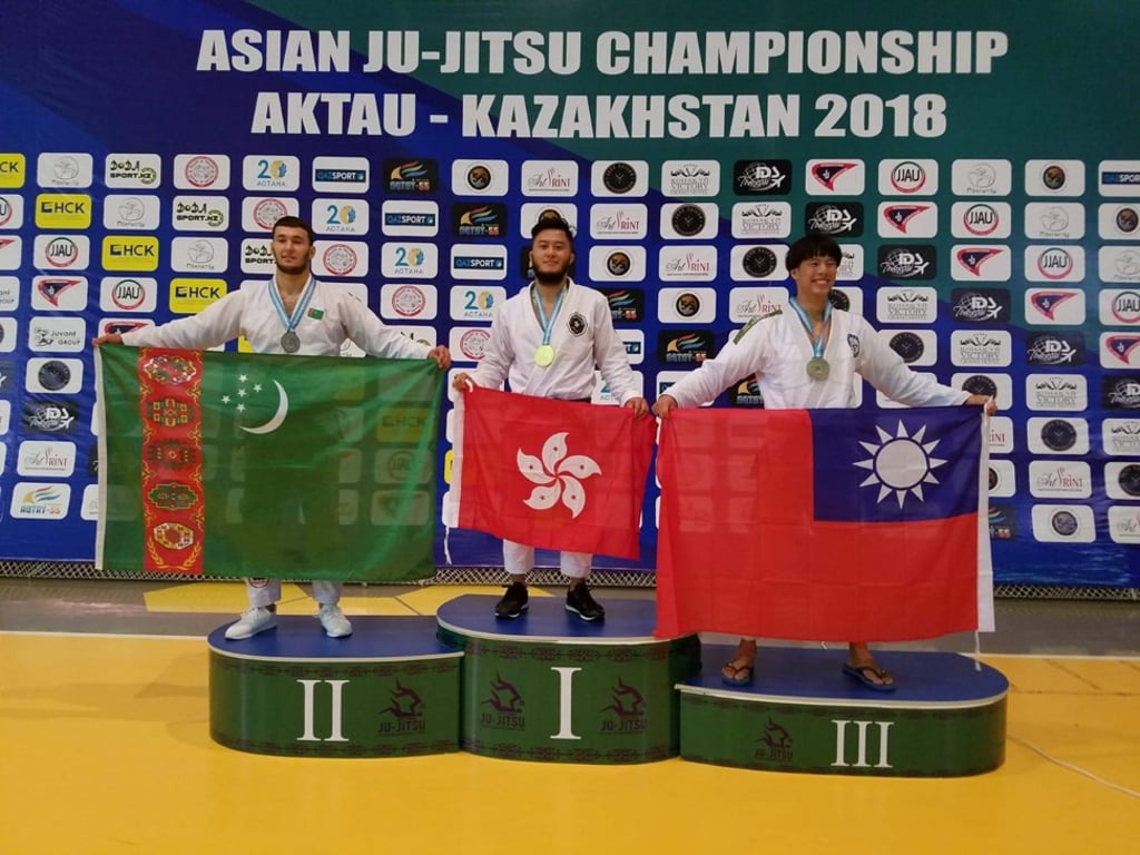 Viking Wong holds the Hong Kong flag atop the podium.