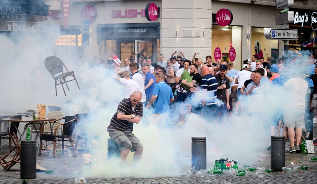England supporters are engulfed in tear gas during clashes with police in Marseille on the eve of England’s Euro 2016 match against Russia. Photo: AFP
