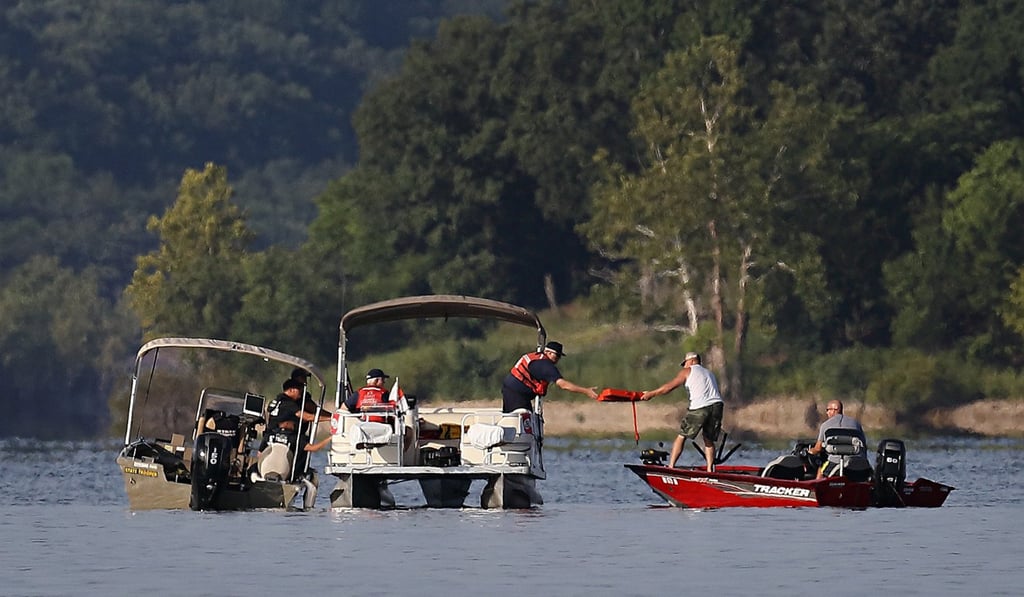 A civilian in a boat hands Missouri State Police officers a life jacket found in Table Rock Lake on Friday, July 20, 2018. Photo: TNS