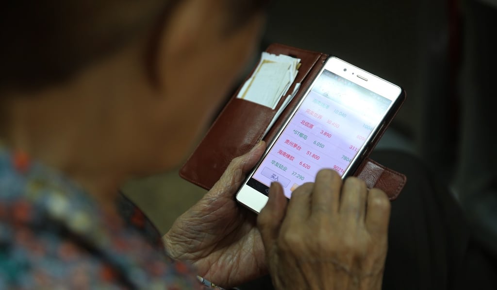 A Chinese investor uses her mobile phone to view the stock prices at a securities brokerage house in Beijing on June 26. Average stock prices at the Shanghai and Shenzhen exchanges have taken a steep hit so far in 2018. Photo: EPA-EFE