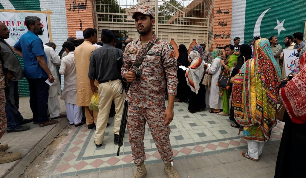 A soldier guards electoral workers in Karachi, Pakistan. Photo: Reuters