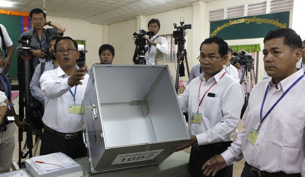 Polling station officers show an empty ballot box before voting begins in the country's general election, at a polling station in Takhmua in Kandal province, southeast of Phnom Penh, Cambodia. Photo: AP
