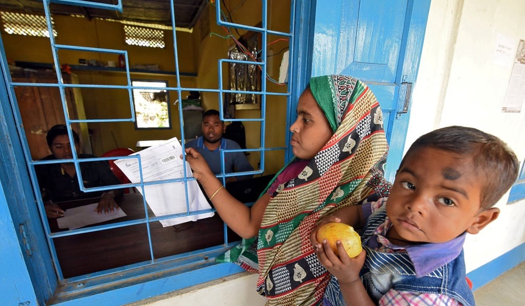 A woman carrying her son arrives to check her name on the draft list of the National Register of Citizens (NRC) in Goalpara district, Assam, in January. File photo: Reuters