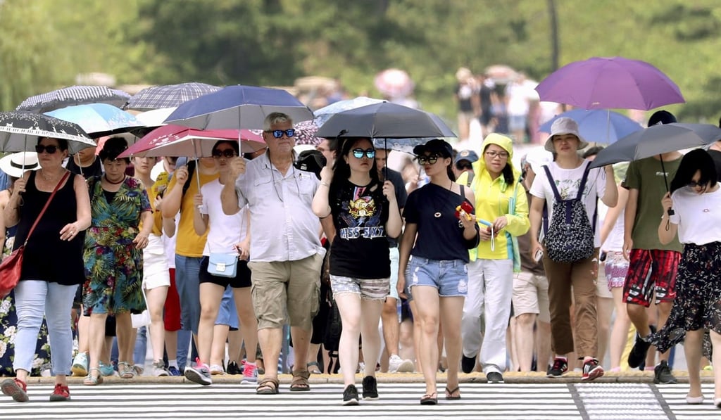 People walking with parasols in Tokyo during the July heatwave. Photo: Kyoto