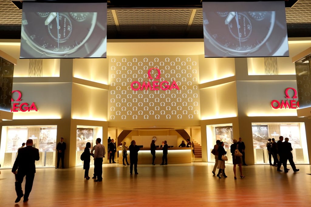 Visitors walk in front of the exhibition stand of Swiss watch manufacturer Omega at the 2013 Baselworld trade fair. Photo: Reuters