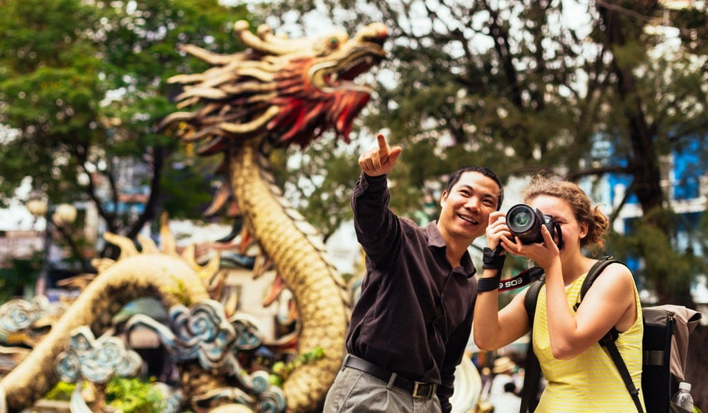 A local guide takes a visitor on a walking tour of Ho Chi Minh City, Vietnam.