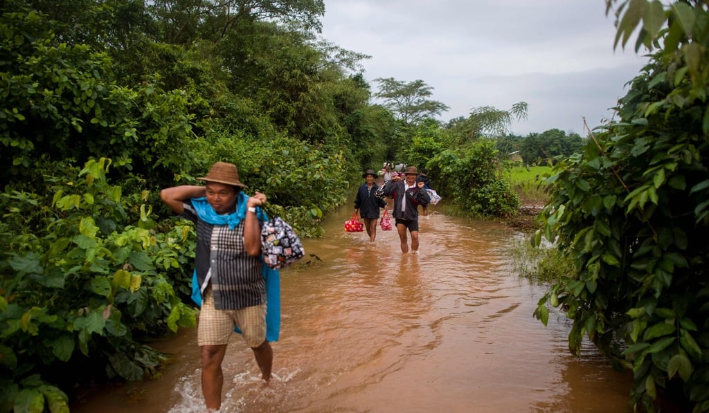 Residents carry relief goods in Shwegyin. Fears have grown that dams in the area may burst. Photo: AFP