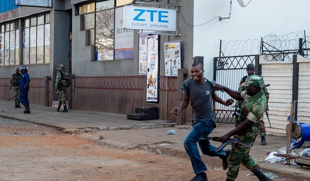 A man suspected of being a protester struggled with a soldier. The Zimbabwean army was called in to quell the protests in Harare and began firing live rounds. Photo: EPA-EFE