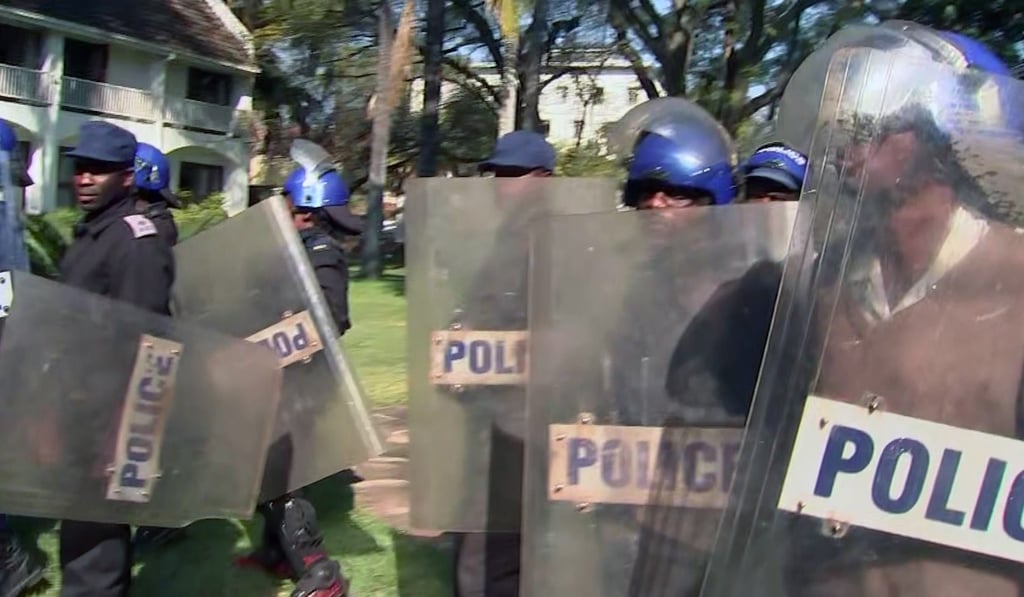 Riot police arriving at the press conference. Photo: AP