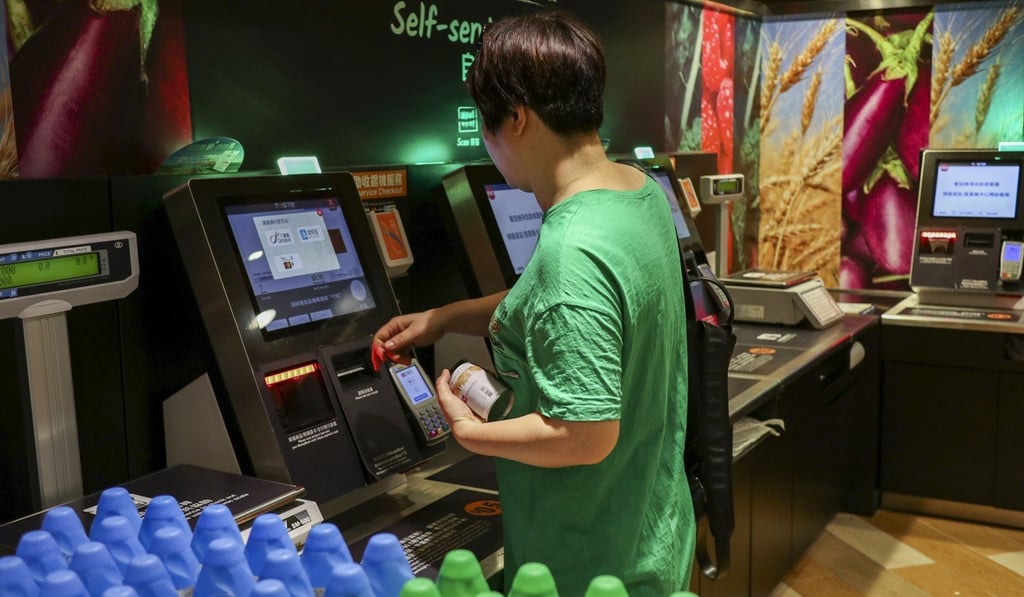 Shoppers try the self-service checkout machines at Taste in Amoy Plaza. Photo: Roy Issa