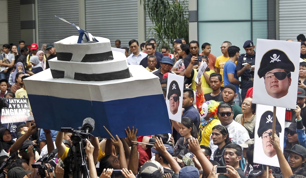 Protesters in Kuala Lumpur holding a model of the luxury yacht Equanimity and pictures of Jho Low dressed as a pirate in April, 2018. Photo: AP