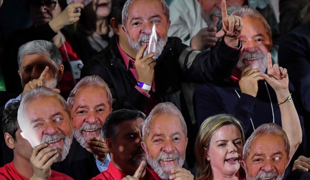 Supporters of Lula holding masks with his likeness during the national convention of the Workers Party. Lula is serving a 12-year jail term. Photo: AFP