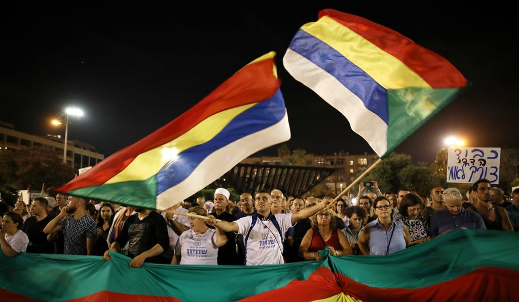 A man with Druze flags in Rabin Square in Tel Aviv on Saturday. Photo: Reuters