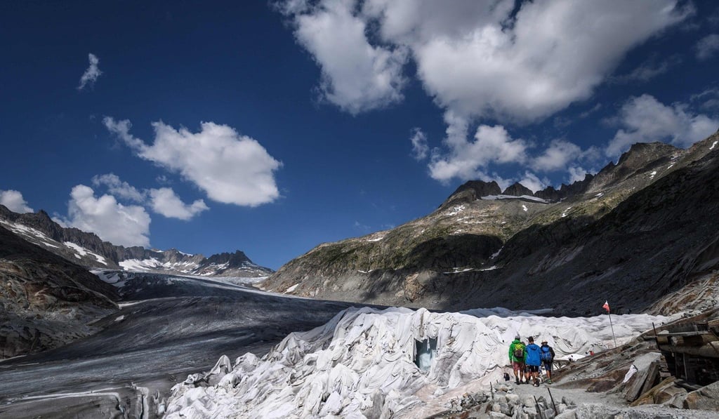 Hikers walk next to a part of the Rhone Glacier, covered with insulating foam to prevent it from melting, near Gletsch on August 3, 2018, as a heatwave sweeps across northern Europe. Photo: Agence-France Presse Hikers walk next to a part of the Rhone Glacier, covered with insulating foam to prevent it from melting, near Gletsch on August 3, 2018, as a heatwave sweeps across northern Europe. Photo: Agence-France Presse