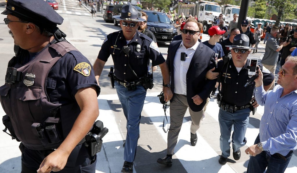Jones, centre right, being escorted by police out of a crowd of protesters outside the Republican convention in Cleveland, Ohio, in 2016. Photo: AP Jones, centre right, being escorted by police out of a crowd of protesters outside the Republican convention in Cleveland, Ohio, in 2016. Photo: AP