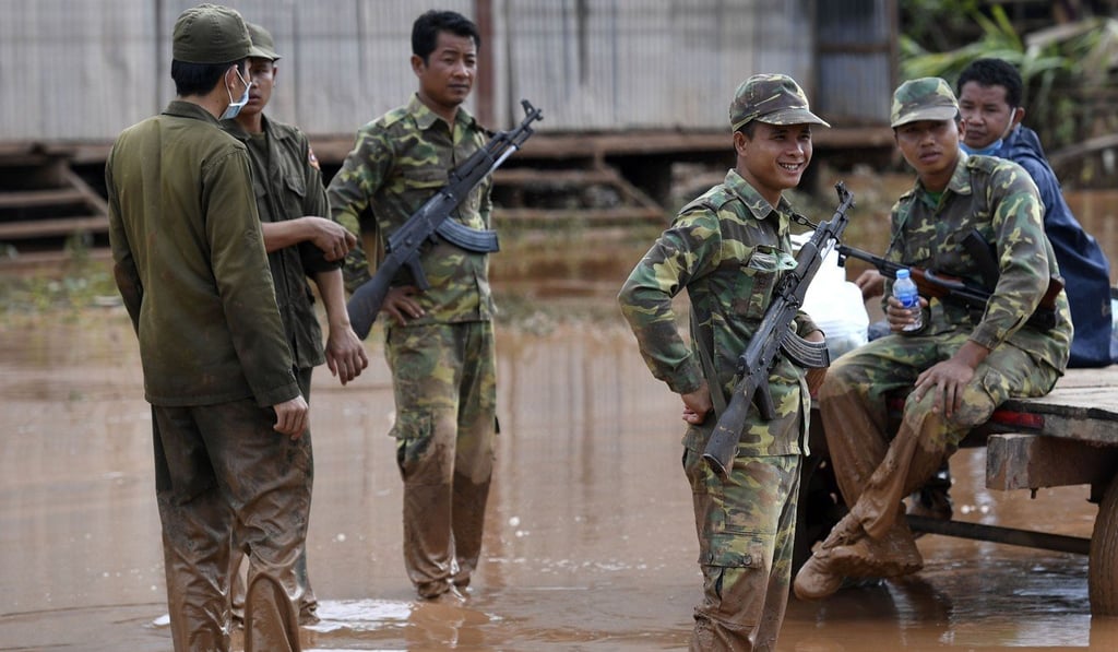 Armed Laos soldiers secure a flooded village in Sanamxai, Attapeu province. Photo: AFP