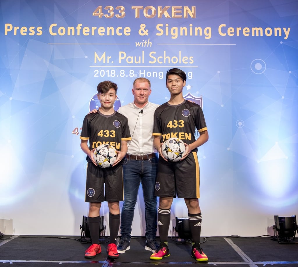 Paul Scholes presents teenagers Matt Chan (left) and Jamie Yau (right) with autographed 433 Token footballs following a dribble demonstration by the two local talents. Photo: Ike Li/Ike Images