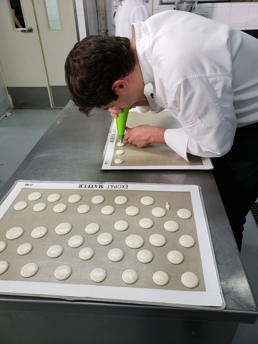 Ken Thomas, head pastry chef at Hong Kong’s DALLOYAU Paris, pipes the macaron shells onto a rubber baking sheet. Photo: Aydee Tie