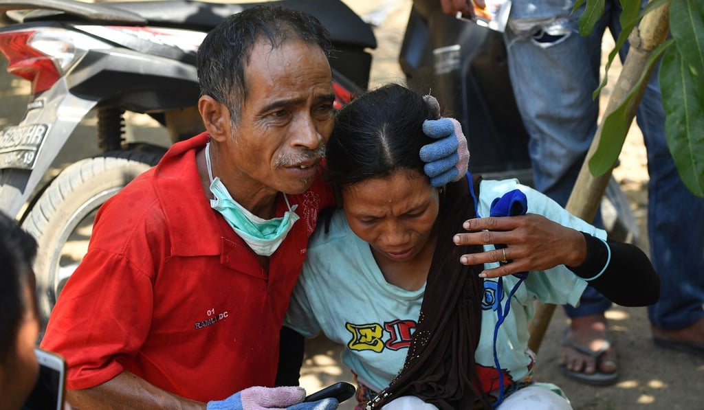 An Indonesian man tries to calm a woman after an aftershock hits Lombok island on Thursday. Photo: AFP