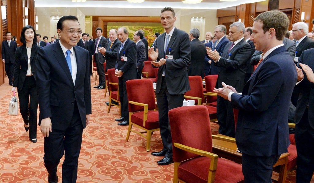 Mark Zuckerberg applauds the arrival of Premier Li Keqiang in the Great Hall of the People. Photo: Reuters