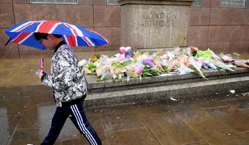 A pedestrian walks past floral tributes to victims of the London Bridge and Borough Market attacks in central London in June 2017. Photo: Reuters