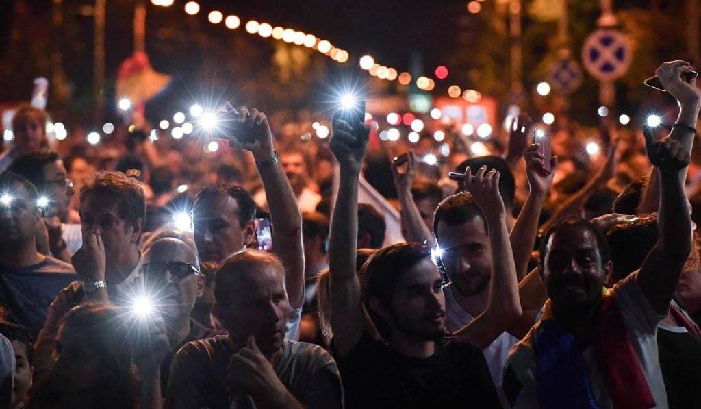People hold up their phones during a demonstration to protest against the government on Saturday in front of the government’s headquarters in Bucharest, Romania. Photo: AFP People hold up their phones during a demonstration to protest against the government on Saturday in front of the government’s headquarters in Bucharest, Romania. Photo: AFP
