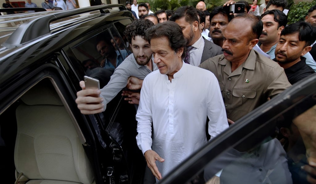 A man takes a photo with Imran Khan as he leaves a party meeting in Islamabad on August 6, 2018. Photo: AP