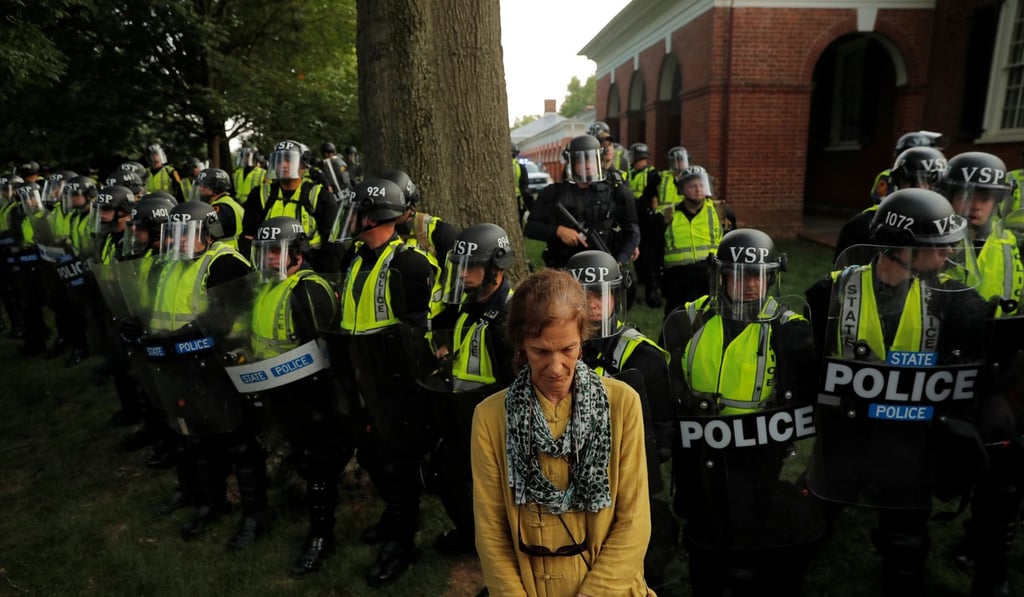 A protester stands in front of Virginia State Police officers forming a cordon at the University of Virginia on August 11, 2018. Photo: Reuters