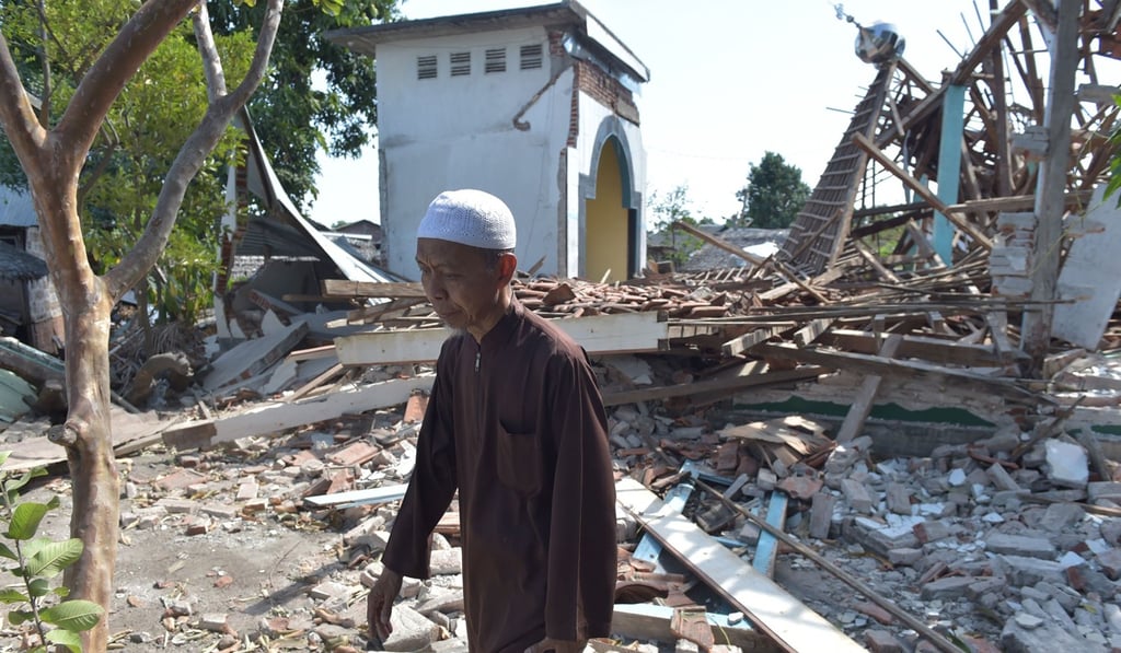 A man walks next to a damaged mosque. Photo: AFP