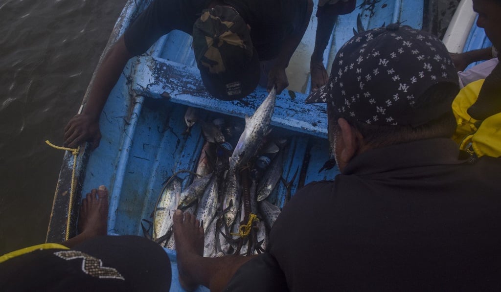 Fishermen on July 12, 2018, ride in a boat where some have been either robbed and/or killed by Venezuelan pirates, in the waters between Venezuela and Trinidad. Photo: Washington Post photo by Jahi Chikwendiu