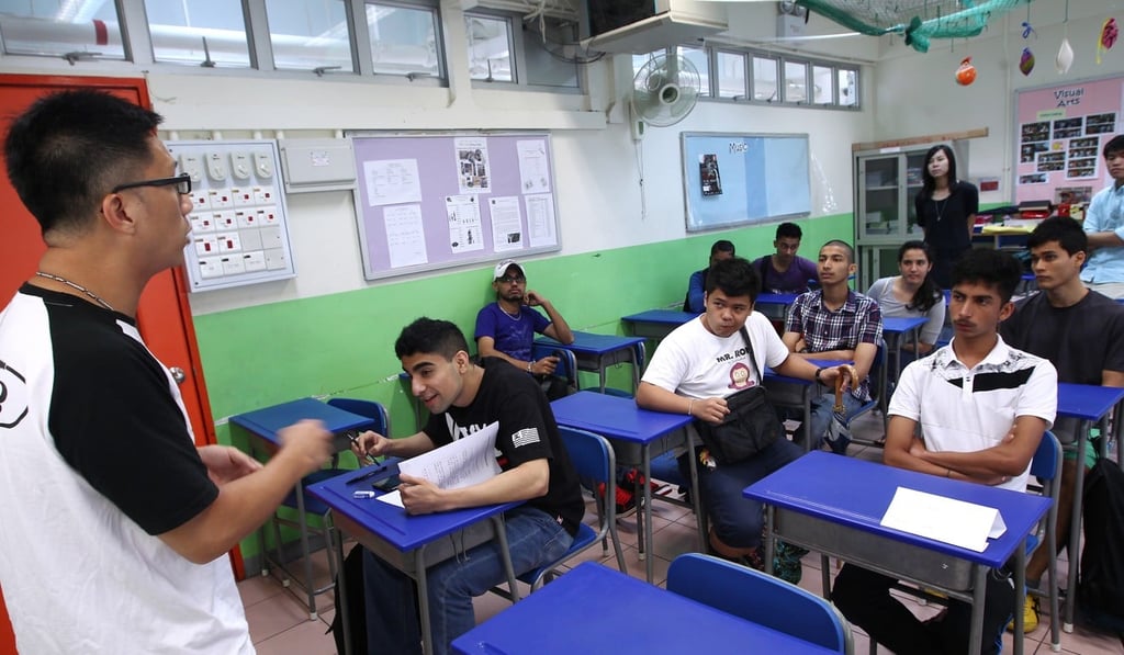 Non-ethnic-Chinese students practise their Cantonese with Senior Police Constable Ka Wai (left), a volunteer for Project Gemstone, at a school in Yau Ma Tei in June 2014. Project Gemstone helps Junior Police Call members to overcome language barriers by providing regular language classes and other activities, and so improve jobs prospects. Photo: Jonathan Wong