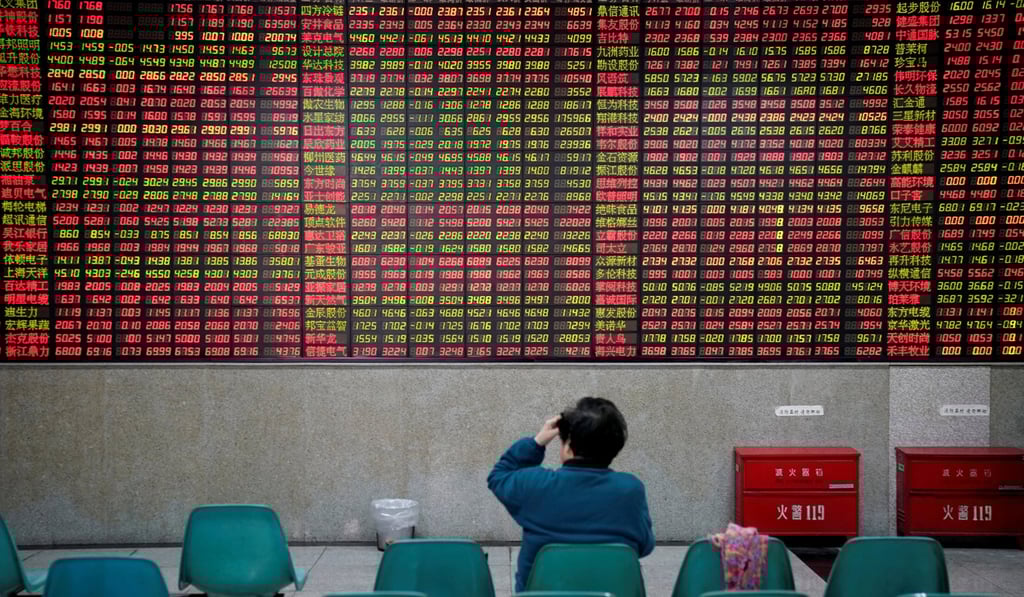 An investor looks at an electronic board showing stock information at a brokerage house in Shanghai. China’s bond market has surged even as its currency has plummeted and the Shanghai Composite Index has fluctuated wildly. Photo: Reuters