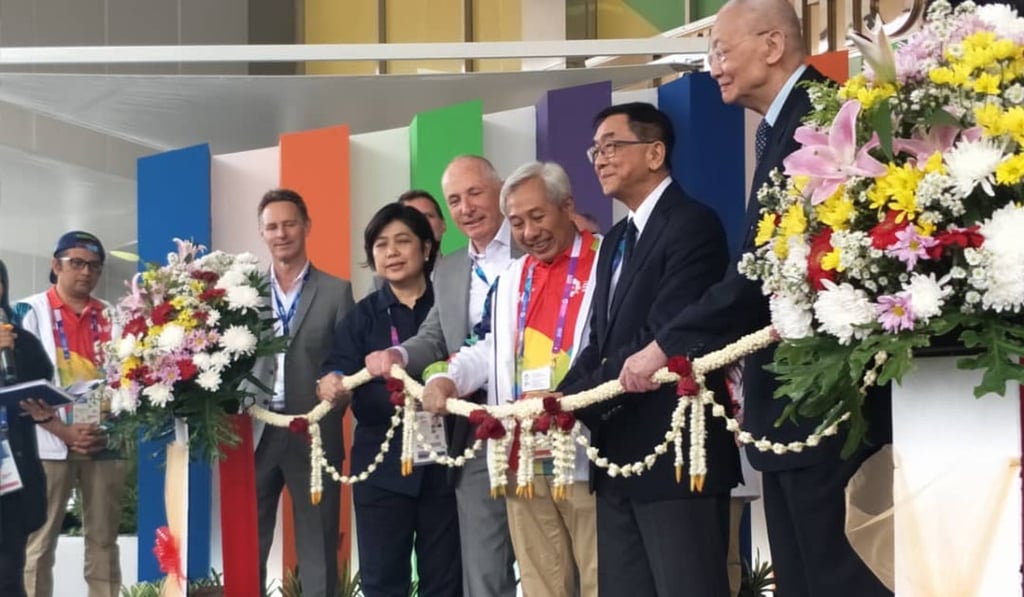 Officials cut the garland ribbon to open the Asian Games Media Centre.