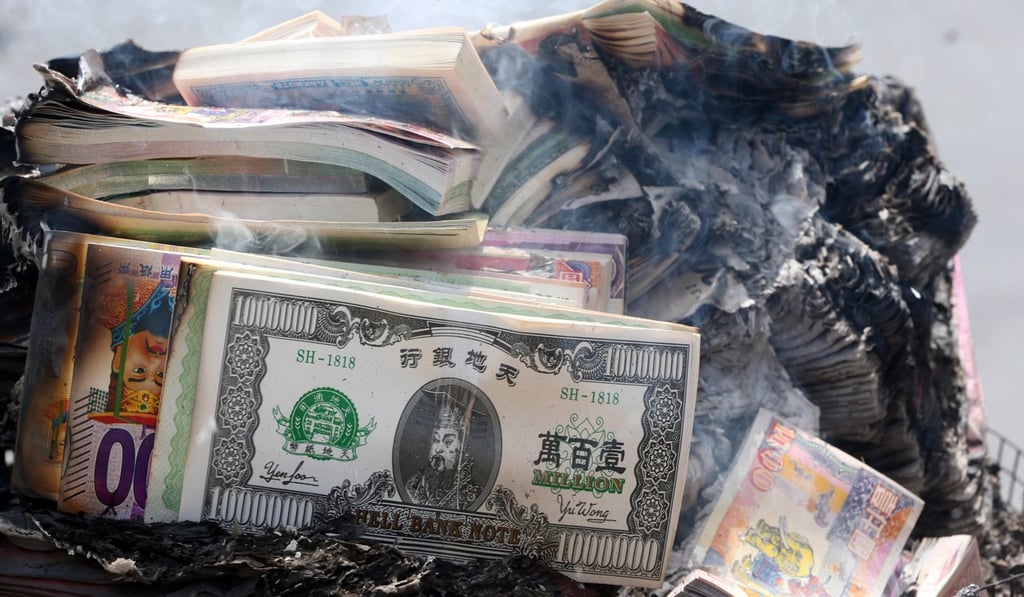 People burn hell bank notes during the festival.