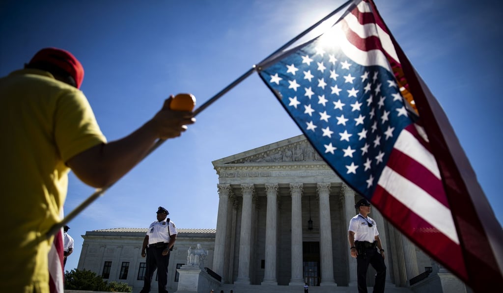 A person waves an American flag outside the US Supreme Court in June. If the American empire is beginning to fracture, the global consequences may well be far more negative than the empire’s evils. Photo: Bloomberg