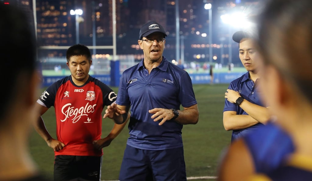 Coach James Elliot gives instructions at tag rugby team training and trials.