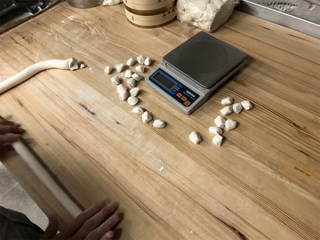Split the dough into equally sized pieces by measuring their weight. Split the dough into equally sized pieces by measuring their weight.