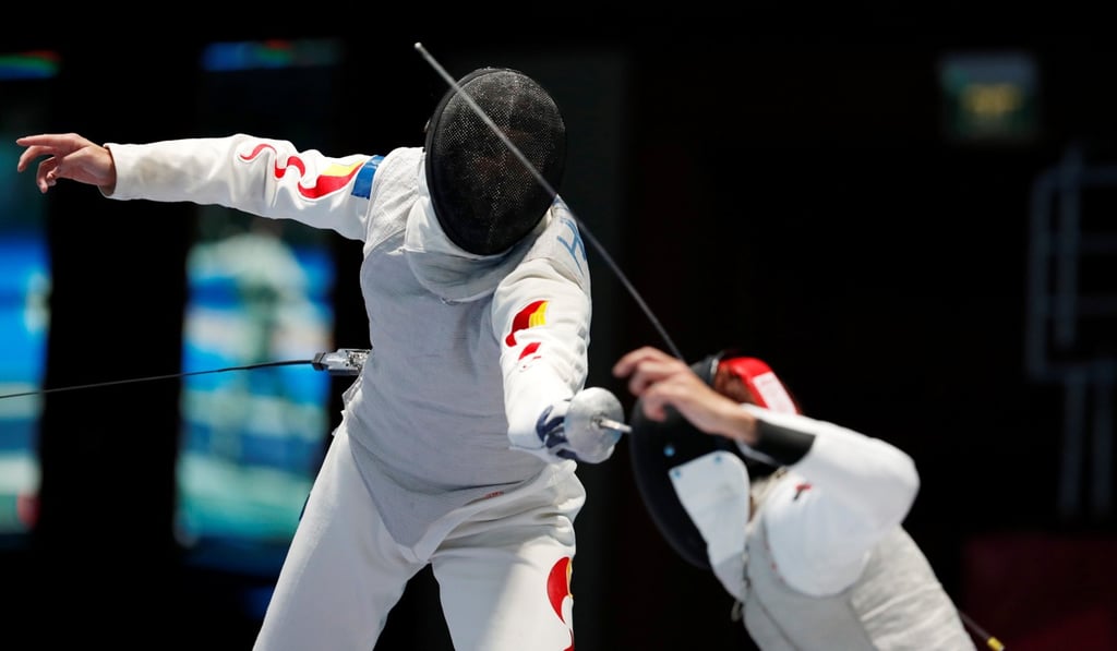 Huang Mengkai of China in action with Nicholas Choi of Hong Kong in the final of the men’s foil. Photo: Reuters