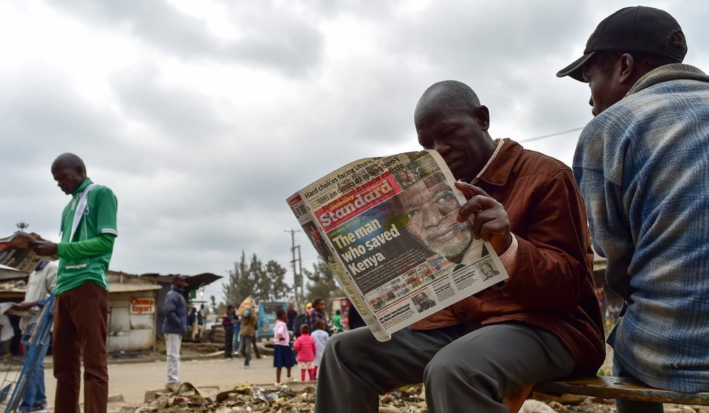 Two men in Kenya read a local newspaper dedicated to Kofi Annan's legacy. Photo: AFP