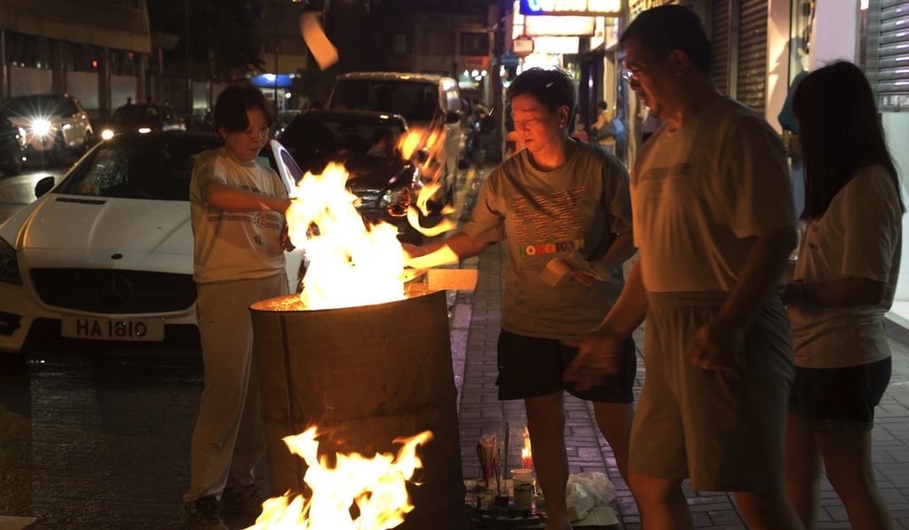 People burn ‘hell money’ as offerings to spirits during the Hungry Ghost Festival. Photo: AP/Kin Cheung