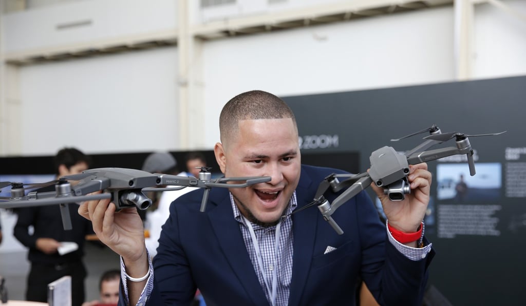 A man poses with the newly-released DJI Mavic 2 Pro (R) and Mavic 2 Zoom drones during the launching ceremony in New York, the United States. Photo: Xinhua A man poses with the newly-released DJI Mavic 2 Pro (R) and Mavic 2 Zoom drones during the launching ceremony in New York, the United States. Photo: Xinhua