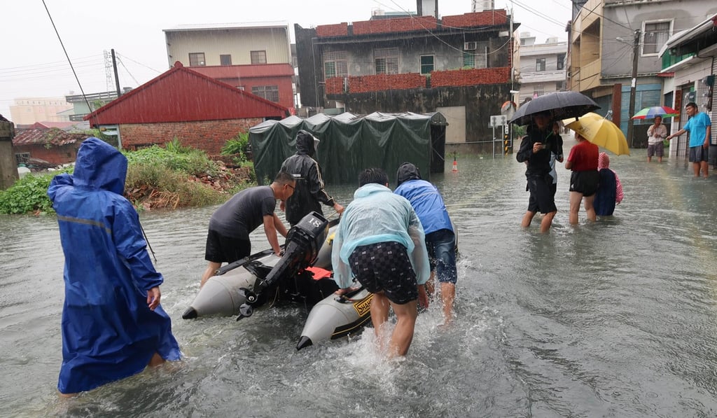 Emergency services and government officials use rafts to carry food to victims of the flooding in Kaohsiung. Photo: CNA
