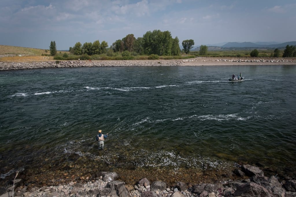 Fishing in the Snake River in Jackson Hole, Wyoming, U.S., on Thursday, Aug. 23, 2018. Federal Reserve Chairman Jerome Powell's debut address to the Wyoming gathering of central bankers this week will do little to shake financial markets if history is any guide. Photo: Bloomberg