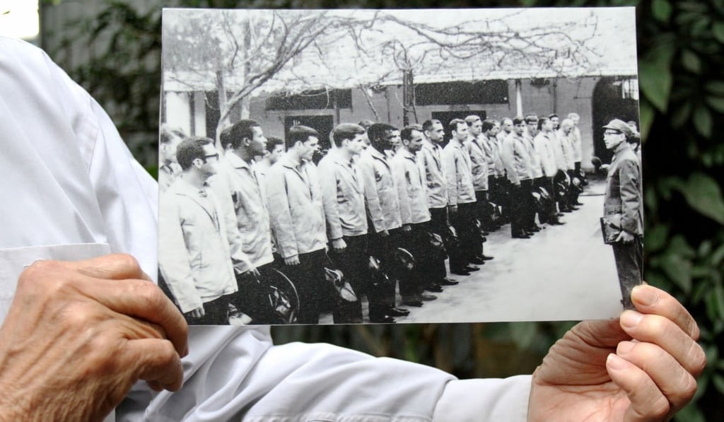 Tran Trong Duyet holds a photo of himself with US prisoners of war at the jail dubbed the ‘Hanoi Hilton’. Photo: AFP