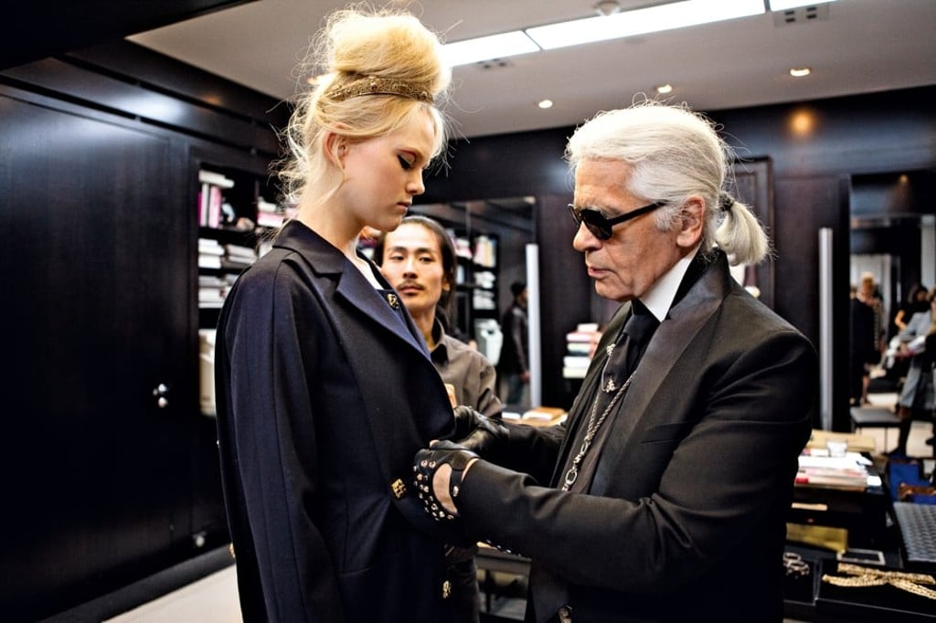 Karl Lagerfeld puts the final touch to a model’s coat at the 2010/11 Paris-Byzance Metiers d’Art collection show. Photo: Benoit_Peverelli