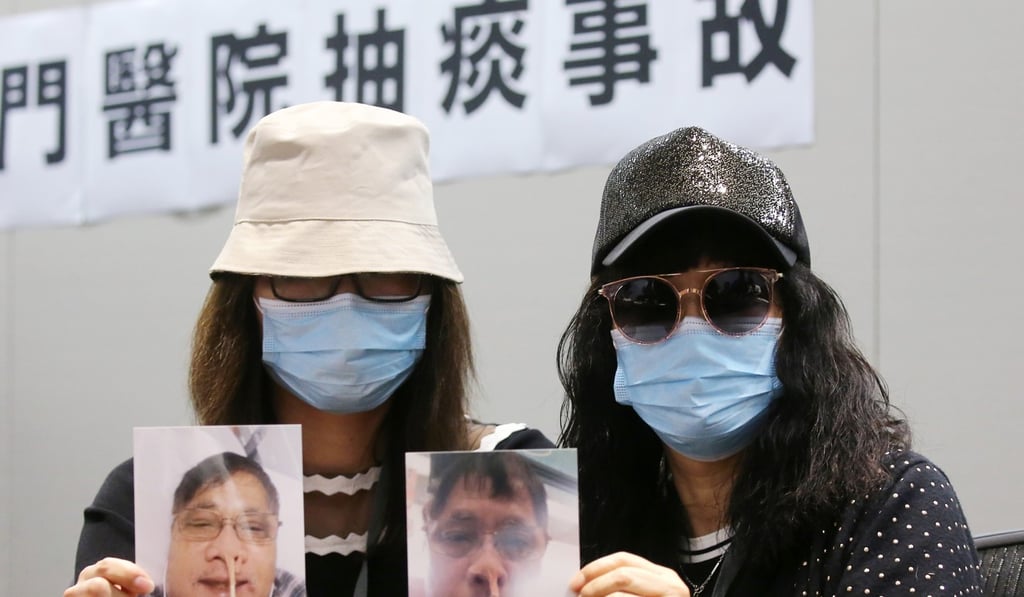 Tong’s daughter (left) and wife hold up pictures of him. Photo: Dickson Lee