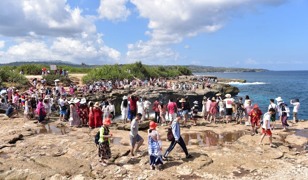 Chinese tourists crowd The Devil's Tears outcrop on Nusa Lembongan, an island off Bali. Picture: Shutterstock